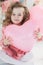 Cute six year old girl in pink dress with pink balloons in the shape of heart