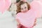 Cute six year old girl in pink dress with pink balloons in the shape of heart