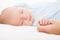 Cute sleeping newborn baby child holding mother hand