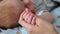 Cute sleeping newborn baby holds mother finger