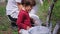 Cute small boy and his young mother painting the tree with the white chalk in the garden they care after the nature