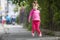 Cute small funny smiling toothless girl in pink casual clothing