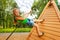 Cute small girl climbs on wooden construction