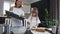 Cute small girl making cookies from raw dough in the form of hearts and stars. Beautiful woman puts baking tray on