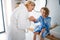 A cute small girl with mother in bathroom indoors at home, painting nails.