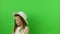 Cute small girl sings on chroma key background. Little girl dressed in a romantic dress. White hat and wedding dress