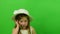 Cute small girl uses mobile phone on chroma key background. Little girl dressed in a romantic dress. White hat and