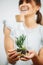 Cute small plant inside a glass bottle presented by a happy woman