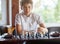 Cute, smart, 11 years old boy in white shirt sits in the classroom and plays chess on the chessboard. Training, lesson, hobby