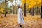 Cute smiley woman holding autumn leaves in nature.