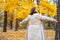 Cute smiley woman holding autumn leaves in nature.