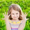 Cute smiling blond little girl with many-coloured manicure