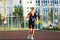 Cute smiling boy in blue t shirt plays basketball on city playground. Active teen enjoying outdoor game with orange ball.