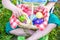 Cute smiling boy holding basket with colorful eggs after easter egg hunt