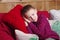 Cute smiling boy lying on a red knitted pillow. Christmas decoration