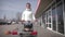 Cute smiling boy sitting in shopping cart. Happy family goes shopping.