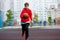 Cute smiling boy in t shirt plays basketball on city playground. Active teen enjoying outdoor game with orange ball. Hobby,