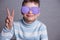 Cute smiling boy in violet sunglasses with opaque lenses showing