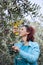 Cute smiling brunette woman harvesting organic olives