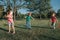 Cute smiling Caucasian preschool girl boys friends playing with hoola hoop in park outside. Kids sport activity. Lifestyle happy