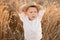 cute smiling child boy in straw hat having fun in wheat field on summer sunset. cottage core concept