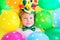 Cute smiling child clown with multicolored balloons. Birthday party concept. April fools' day celebration concept.