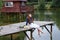 Cute smiling girl with a bouquet of daisies on the pier barefoot dreaming.