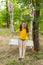 Cute smiling girl having fun on a swing in tree forest