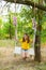 Cute smiling girl having fun on a swing in tree forest