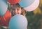 Cute smiling girl peeking through the balloons - Retro look