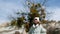 Cute smiling girl standing near tree in scenic valley