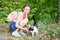 Cute smiling girl strokes a purring cat on the street. Black and white color. Homeless animal.