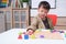 Cute smiling kindergarten boy playing with alphabet blocks, Asian children learning English with wooden educational abc toy puzzle