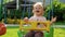 Cute smiling little baby girl swinging on a swing in summer day. Slow motion