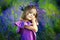 Cute smiling little girl with flower wreath on the meadow at the farm. Portrait of adorable small kid outdoors