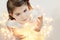 Cute, smiling little girl with glowing Christmas lights