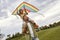 Cute smiling little girl sitting on shoulders of her dad and playing with colorful kite, small daughter and father