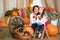 A cute, smiling mother and daughter in a colorful Ukrainian wreath and in embroidered is sitting on haystacks. Autumn decor,