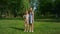 Cute smiling sister hugging brother. Kids pose on green lush field with rackets