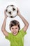 Cute Smiling Soccer Kid Holding Ball above His Head