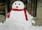 A cute snowman wear a red scarf on snow floor