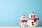 Cute snowmans with red bow against blue background
