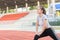 Cute sport woman stretching warm up before running on track