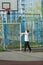 Cute sporty teenage boy playing basketball outdoors preparing for shooting. active lifestyle