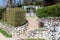 Cute stone tiles wall with ceramic tiles steps leading towards baroque style metal backyard doors next to outdoor lamp surrounded