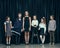 Cute stylish children on dark studio background. The beautiful teen girls and boy standing together