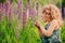 Cute surprised child girl exploring nature with loupe on summer field