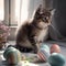 cute sweet grey tabby Baby Cat sitting in a room with window and looking on many beautifull painted easter eggs