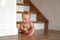 Cute sweet little blonde baby on wooden stairs background