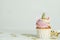 Cute sweet unicorn cupcake and festive decor on white table. Space for text